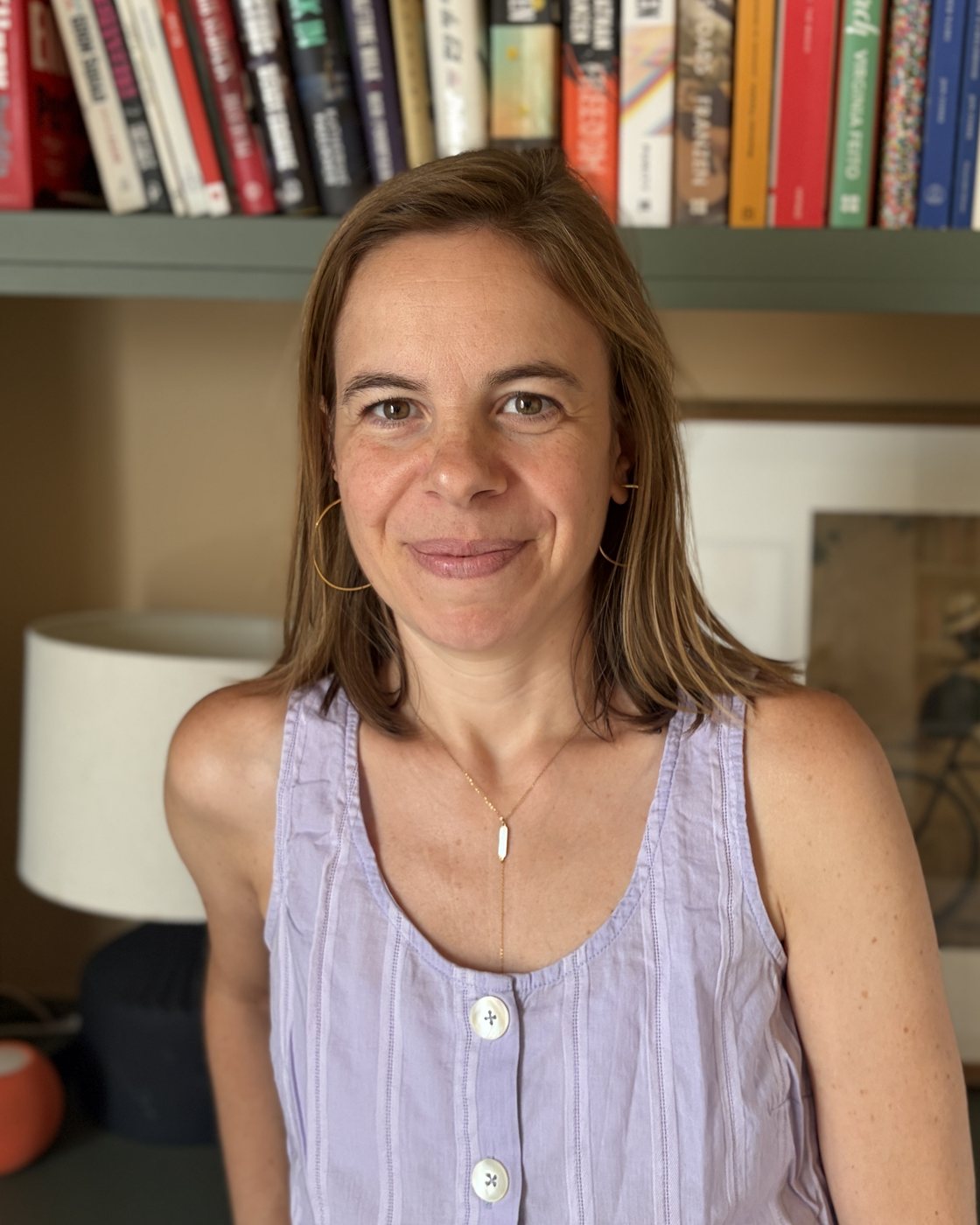 Corinna, smiling, seated in her living room in Barcelona